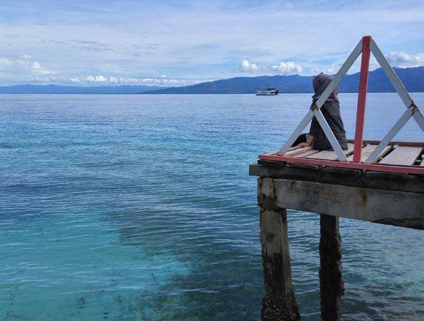 The end of a ruined jetty over clear blue water