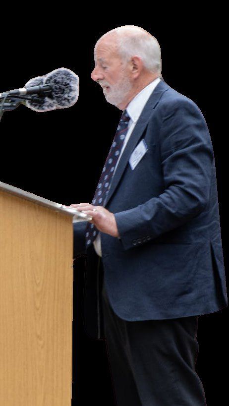 A speaker at a lectern addressing the VJ-Day gathering