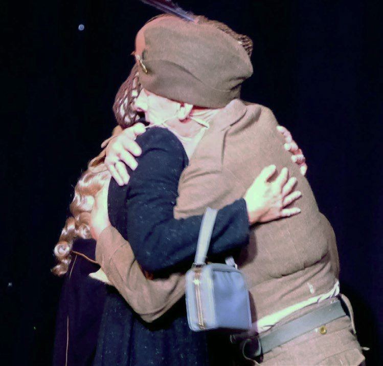 Two actors embracing on stage