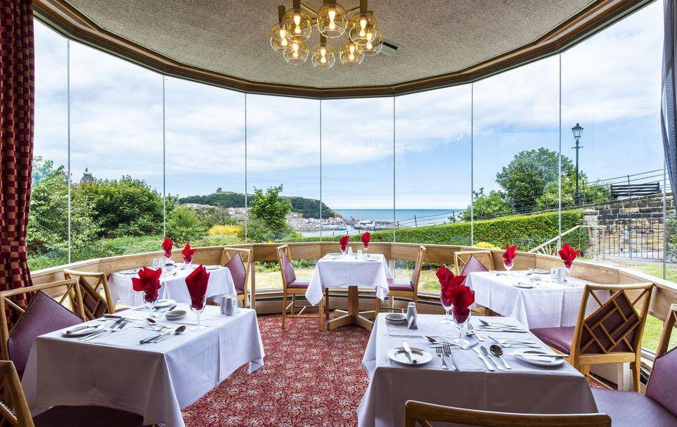 The hotel dining room with sea views through curved windows