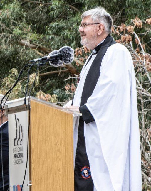 Rev. Richard Brooker leading the service at a lectern